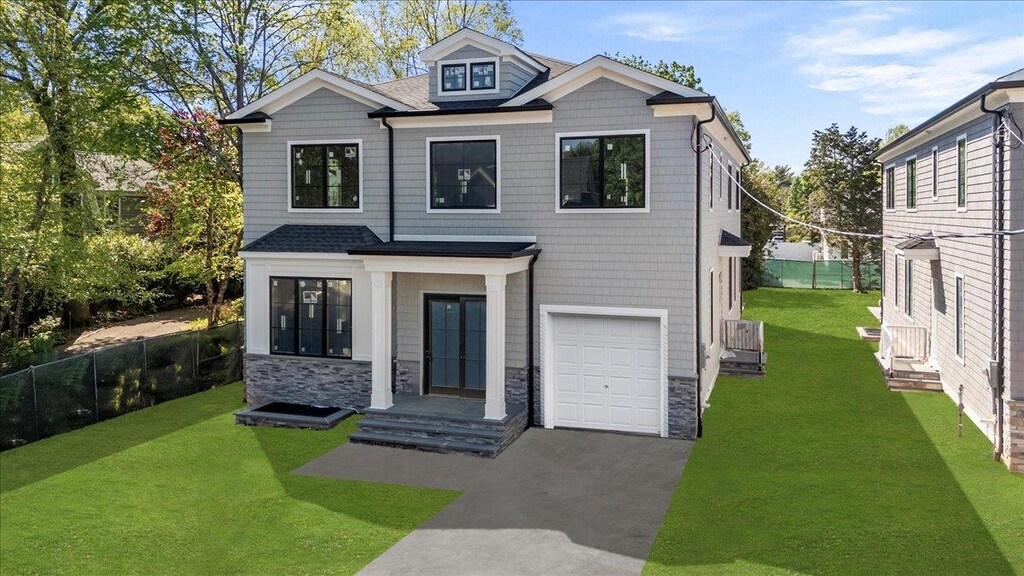 980 Singleton Ave, Woodmere, NY 11598 - contemporary house with an attached garage, stone siding, and driveway