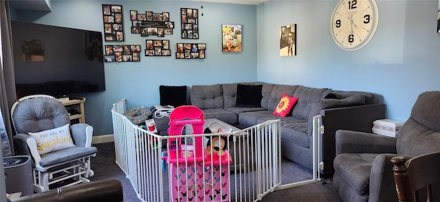 carpeted living area with baseboards
