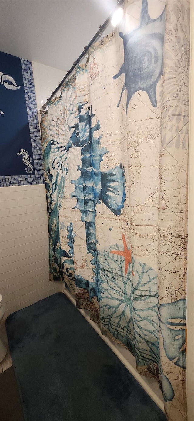 full bath with toilet and a shower with curtain