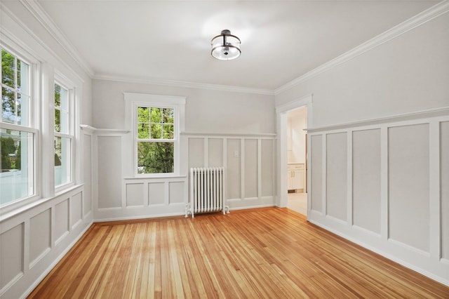 224 Leicester St, Port Chester, NY 10573 - empty room with radiator, a decorative wall, light wood-type flooring, ornamental molding, and wainscoting