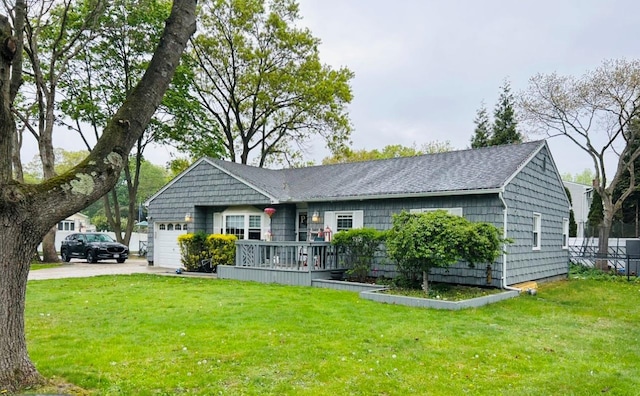 ranch-style house with roof with shingles, an attached garage, concrete driveway, and a front lawn