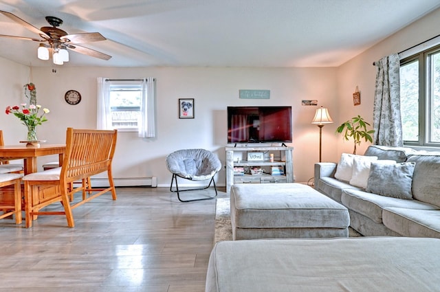 80 Saint Anns Ave, Copiague, NY 11726 - living room with baseboard heating, healthy amount of natural light, a ceiling fan, and wood finished floors