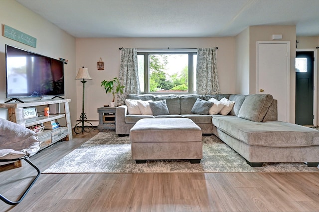 80 Saint Anns Ave, Copiague, NY 11726 - living area with plenty of natural light, wood finished floors, and a baseboard radiator