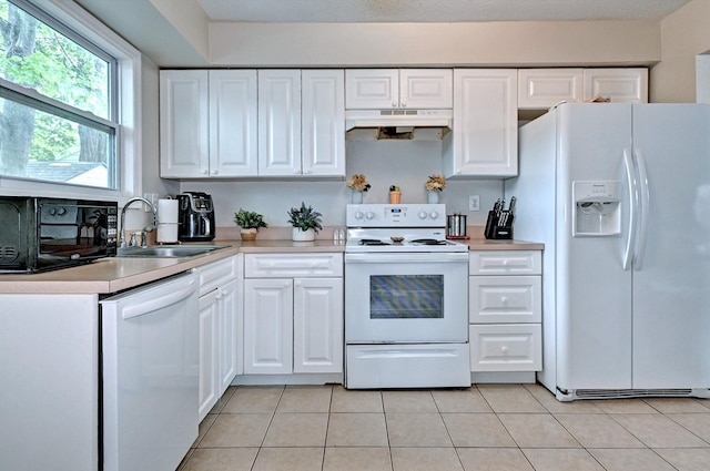 80 Saint Anns Ave, Copiague, NY 11726 - kitchen featuring white appliances, a sink, under cabinet range hood, light countertops, and white cabinetry