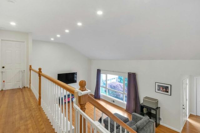 hallway with an upstairs landing, light wood-type flooring, lofted ceiling, recessed lighting, and baseboards