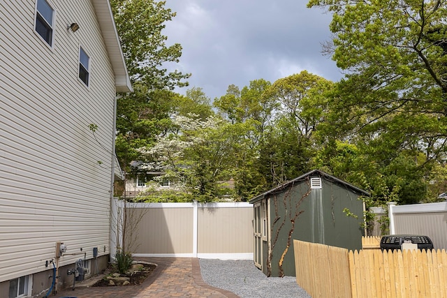 view of property exterior with an outbuilding, a fenced backyard, and a storage unit