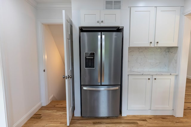 kitchen with tasteful backsplash, stainless steel refrigerator with ice dispenser, visible vents, light wood finished floors, and white cabinets