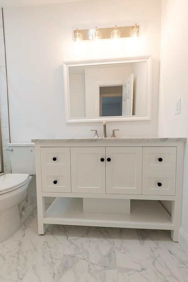 bathroom with toilet, marble finish floor, baseboards, and vanity