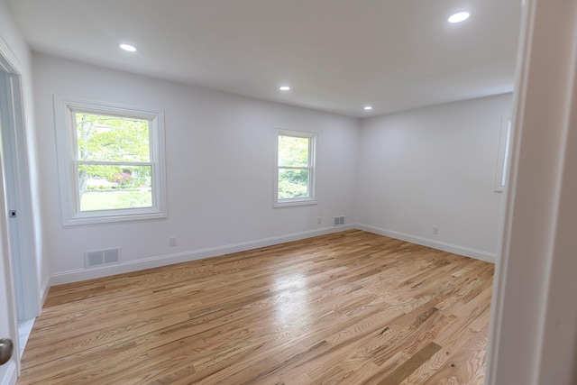 unfurnished room with light wood-type flooring, recessed lighting, and visible vents