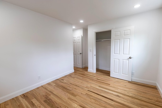unfurnished bedroom with baseboards, recessed lighting, a closet, and light wood-type flooring