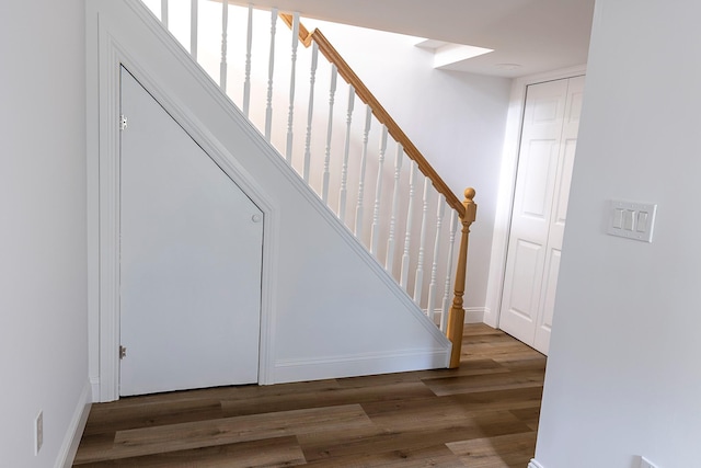 stairs with wood finished floors and baseboards