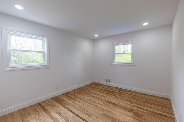spare room with light wood-style flooring, baseboards, visible vents, and recessed lighting