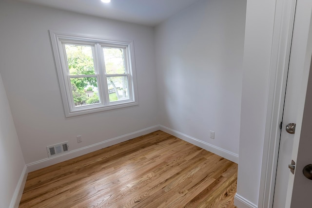 unfurnished room with light wood-type flooring, baseboards, and visible vents