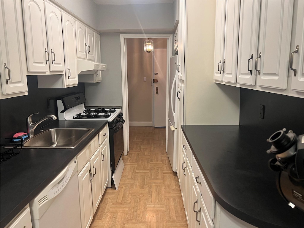 kitchen with black gas range, white dishwasher, a sink, dark countertops, and under cabinet range hood