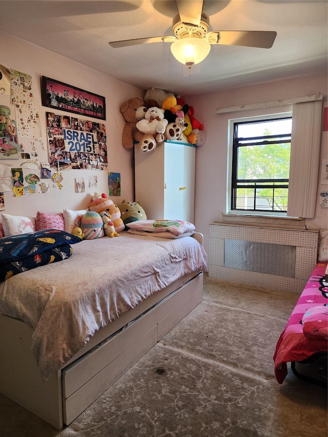 bedroom featuring carpet flooring, a ceiling fan, and radiator heating unit