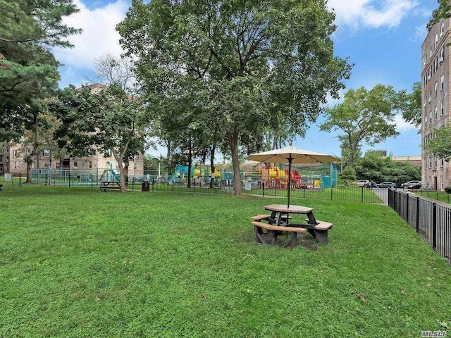 surrounding community featuring a yard, a playground, and fence