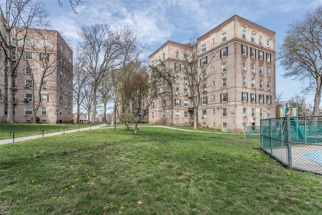 view of home's community featuring a lawn and fence