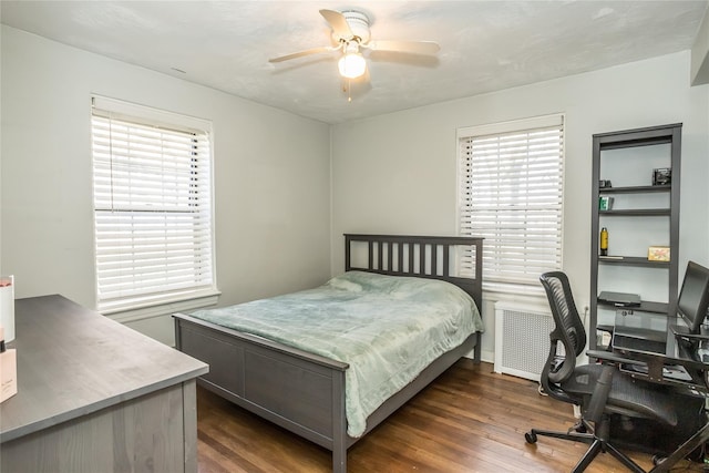 bedroom with multiple windows, ceiling fan, and dark wood-type flooring