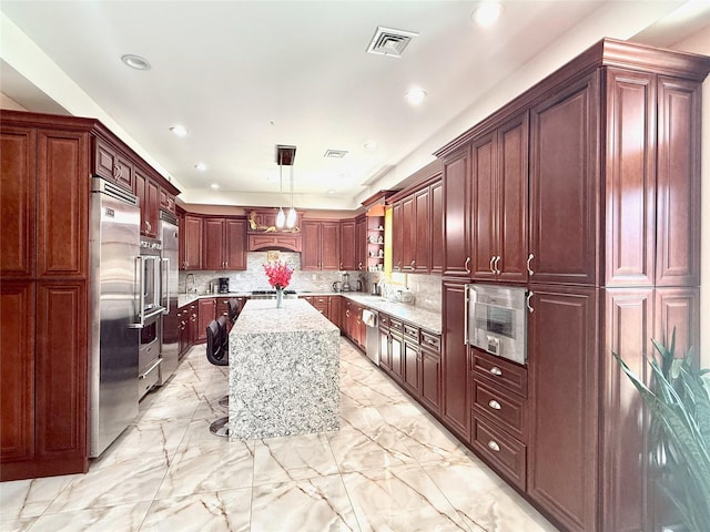 1601 Union Ave, Hewlett, NY 11557 - kitchen featuring hanging light fixtures, a center island, appliances with stainless steel finishes, decorative backsplash, and light stone counters