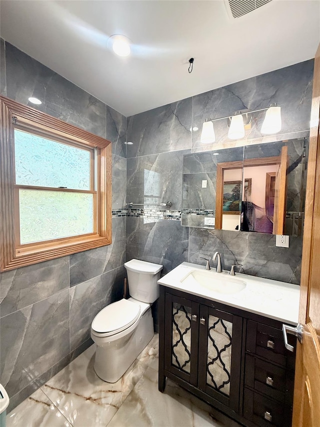 1601 Union Ave, Hewlett, NY 11557 - bathroom with tile walls, toilet, marble finish floor, vanity, and visible vents