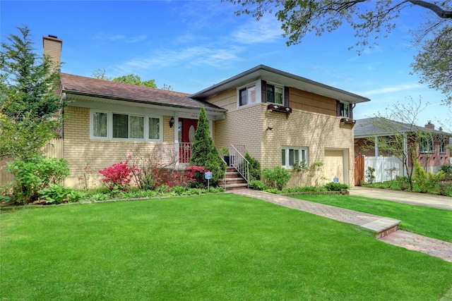 split level home featuring brick siding, driveway, a garage, a front yard, and a chimney