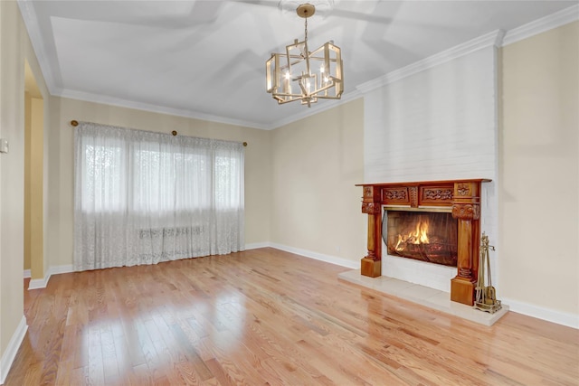 unfurnished living room with wood finished floors, ornamental molding, a fireplace, an inviting chandelier, and baseboards