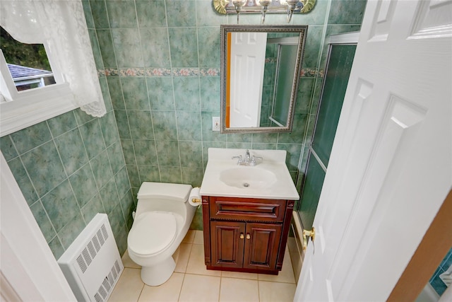 bathroom featuring tile walls, radiator, toilet, vanity, and tile patterned flooring