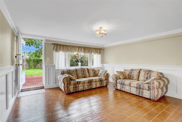 living area with ornamental molding, a decorative wall, and a wainscoted wall