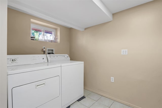 clothes washing area with laundry area, light tile patterned floors, baseboards, and washing machine and clothes dryer