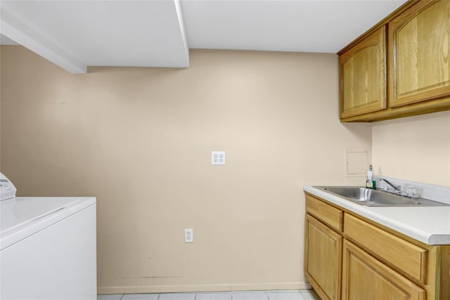 laundry room featuring a sink, cabinet space, washer / dryer, light tile patterned floors, and baseboards