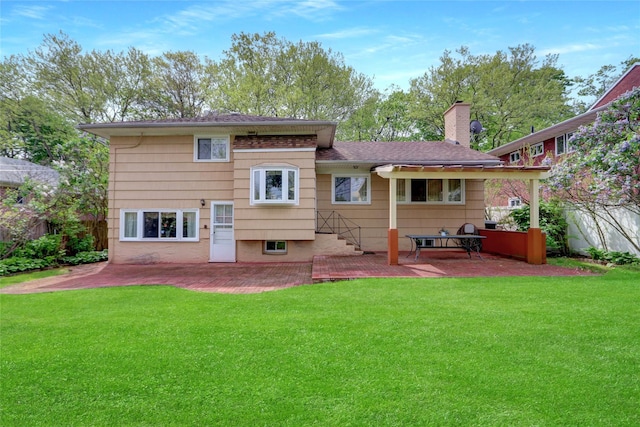 back of house with a patio area, a chimney, and a lawn