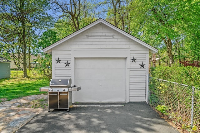 detached garage with fence and driveway