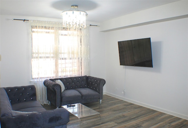 living room with a chandelier, wood finished floors, and baseboards