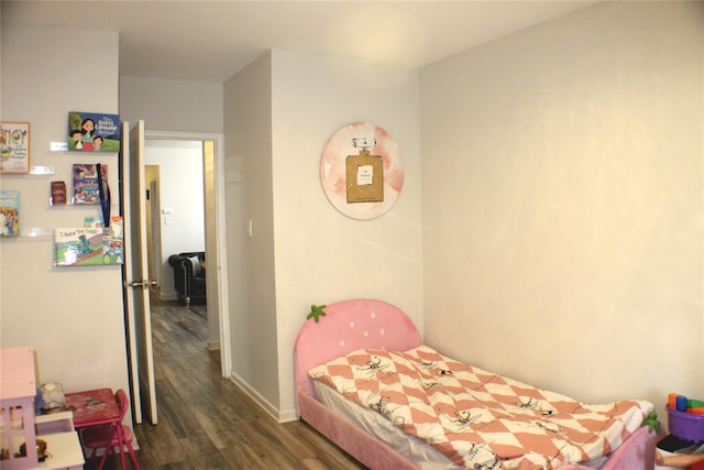 bedroom featuring baseboards and wood finished floors