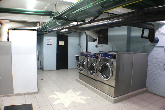 shared laundry area featuring separate washer and dryer and light tile patterned flooring