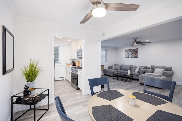 dining room with a baseboard heating unit, ceiling fan, ornamental molding, light wood finished floors, and baseboards