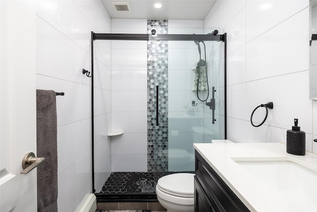bathroom with a stall shower, toilet, vanity, and tile walls