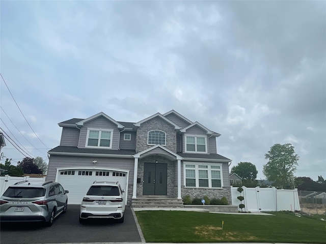 craftsman house with stone siding, aphalt driveway, a garage, and fence