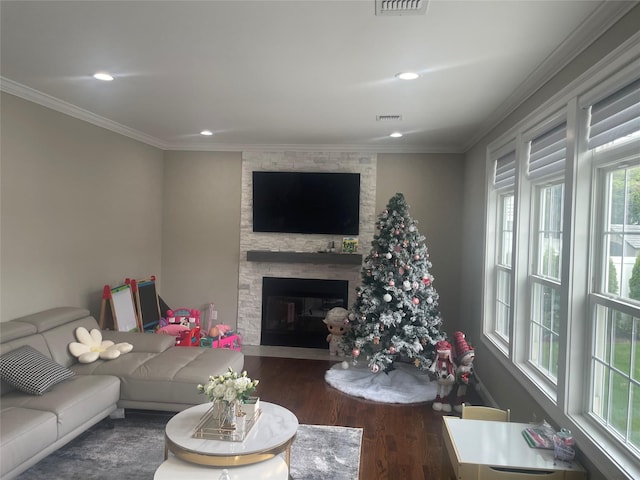 living area with wood finished floors, a fireplace, crown molding, visible vents, and recessed lighting