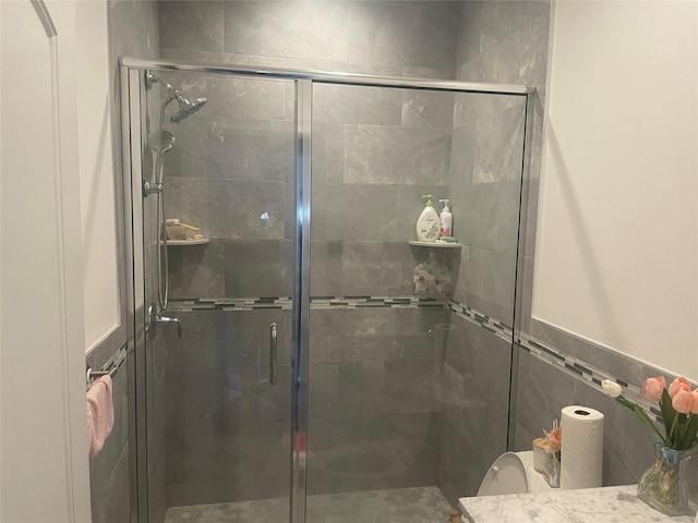 full bathroom with tile walls, toilet, and a stall shower