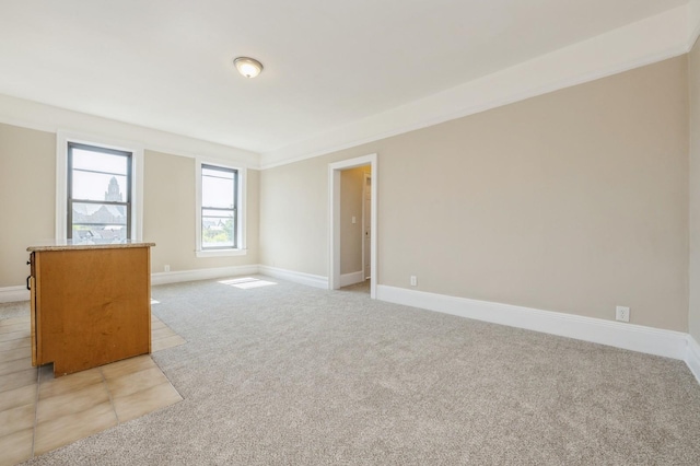 empty room with baseboards and light carpet