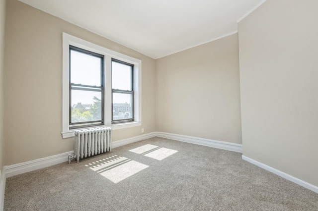 carpeted spare room with radiator, baseboards, and ornamental molding