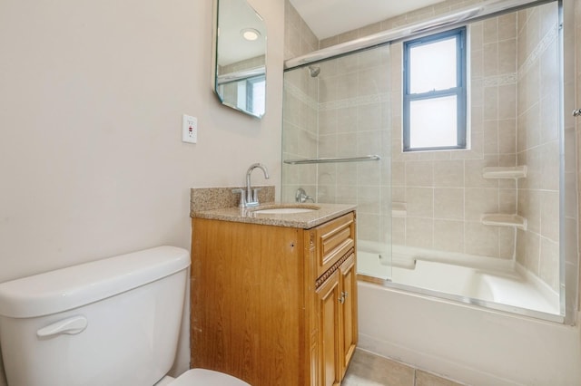 full bath with vanity, tile patterned floors, toilet, and shower / bath combination with glass door