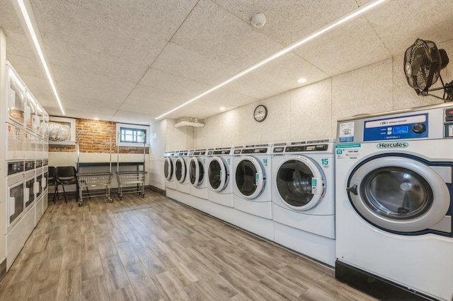 community laundry room with independent washer and dryer, stacked washer and dryer, and wood finished floors