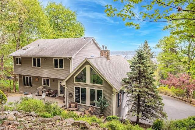 235 S Blvd, Nyack, NY 10960 - back of property with a patio, a chimney, and roof with shingles