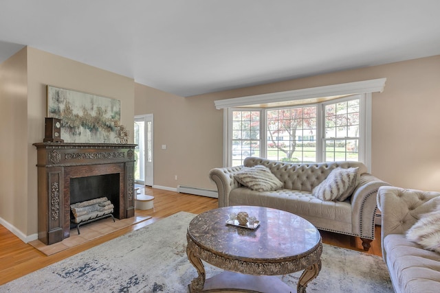 living area featuring light wood-type flooring, baseboards, baseboard heating, and a fireplace