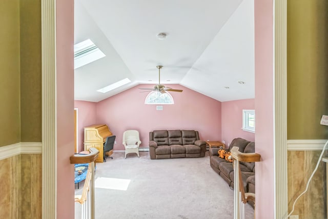 carpeted living room with lofted ceiling with skylight and ceiling fan