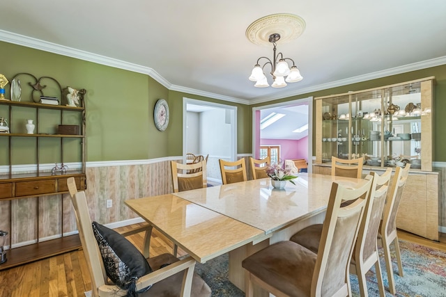 dining room featuring an inviting chandelier, crown molding, and wood finished floors