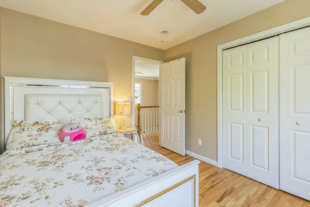 bedroom featuring a closet, light wood finished floors, ceiling fan, and baseboards