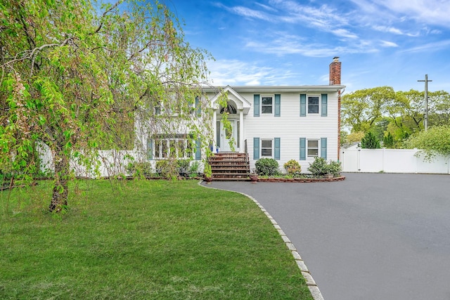 split foyer home featuring a chimney and asphalt driveway
